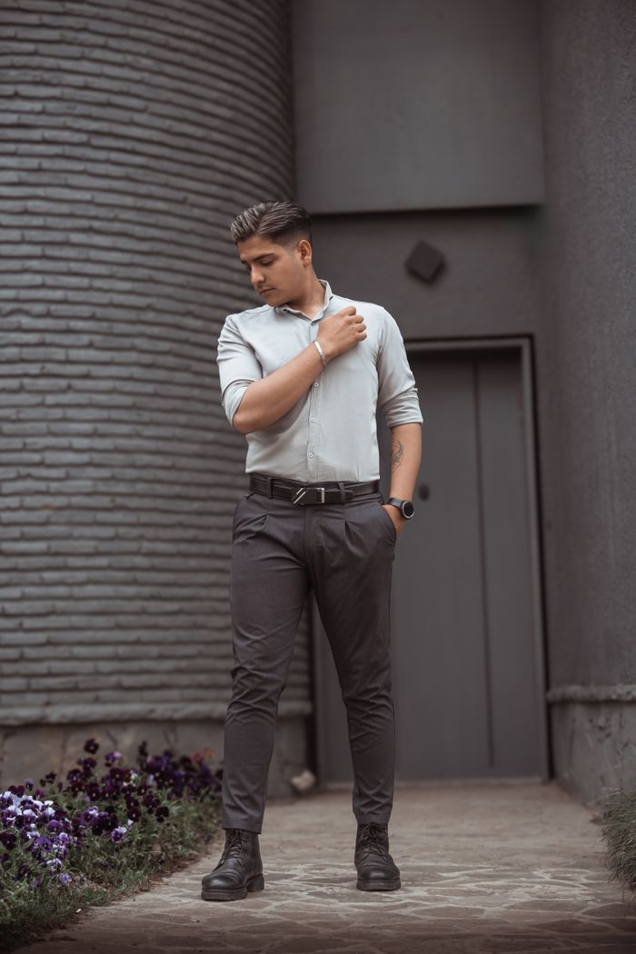faq-img Young man in smart casual attire posing confidently outdoors.