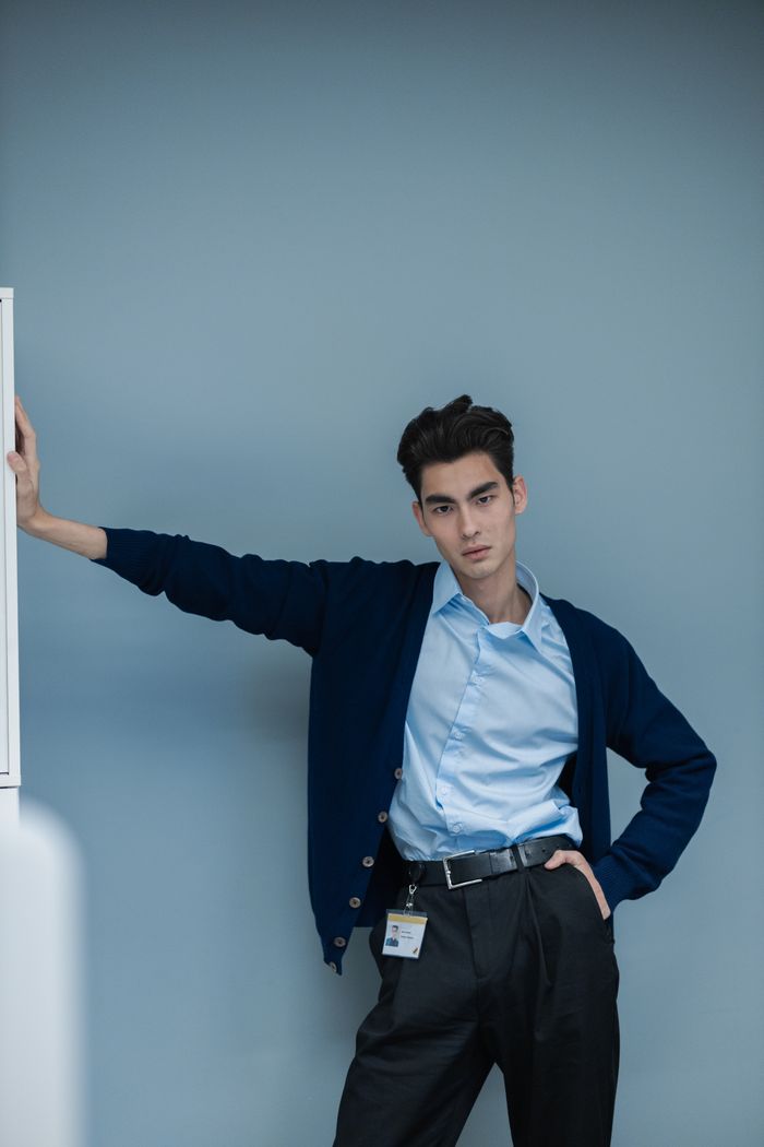our-story-02 A young professional man posing confidently in smart attire against a neutral background.
